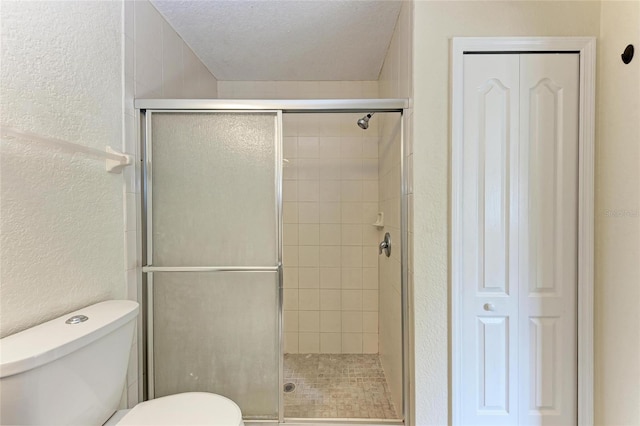 bathroom with toilet, an enclosed shower, and a textured ceiling