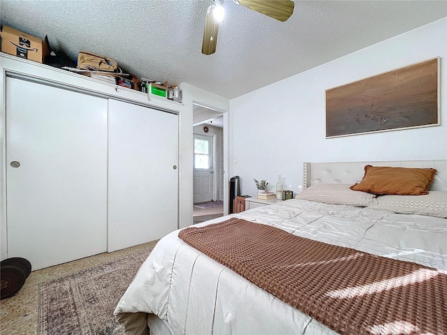 bedroom featuring carpet, a closet, ceiling fan, and a textured ceiling