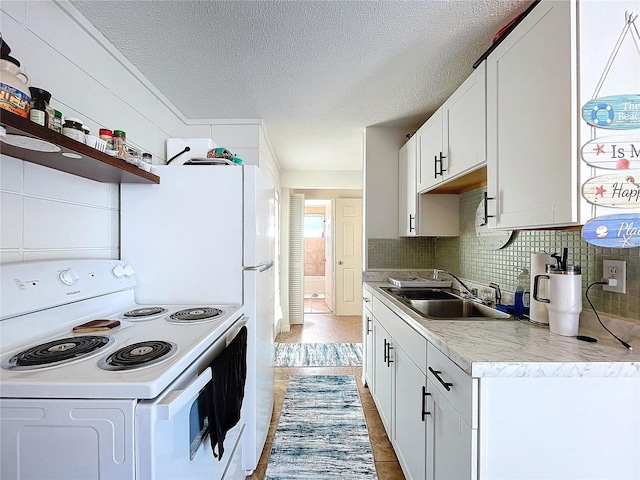 kitchen featuring white electric stove, a sink, white cabinetry, light countertops, and decorative backsplash