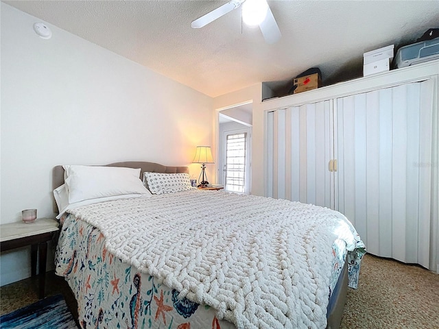 bedroom featuring a ceiling fan, carpet, and a textured ceiling