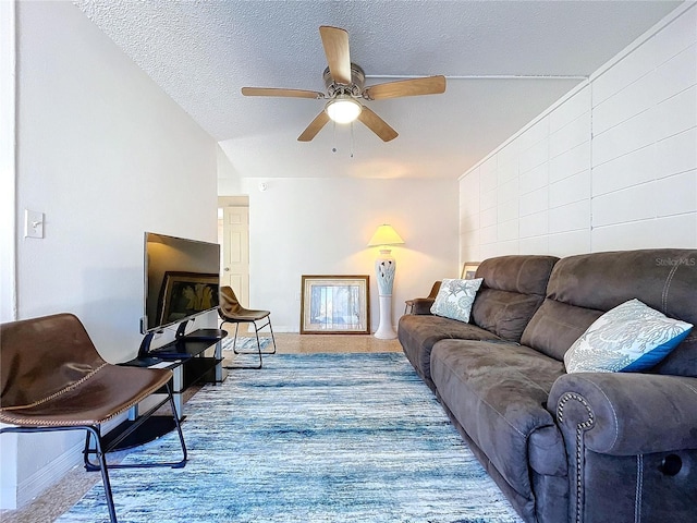 carpeted living area featuring a textured ceiling, a ceiling fan, and baseboards