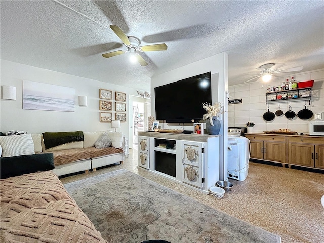 living room with a ceiling fan and a textured ceiling