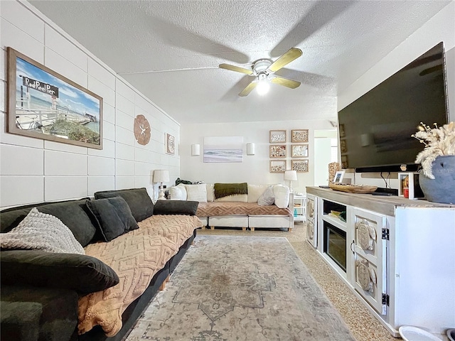 carpeted living area with a textured ceiling and a ceiling fan