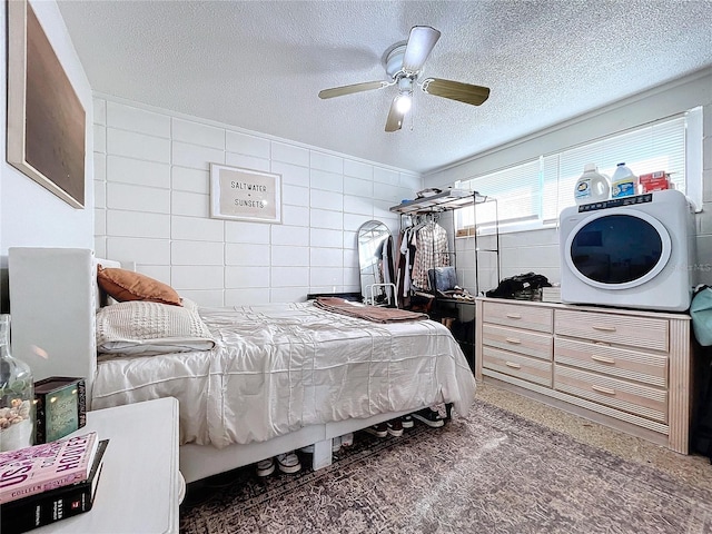 bedroom with a textured ceiling, ceiling fan, and tile walls