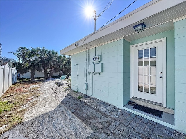 exterior space featuring a patio, concrete block siding, and fence