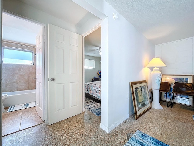 corridor with baseboards and a textured ceiling