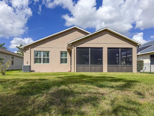 back of house with a lawn, a sunroom, and central air condition unit