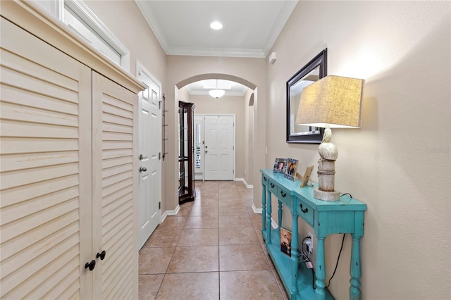 entryway featuring light tile patterned floors and crown molding