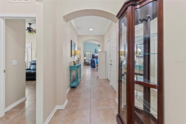 hallway with light tile patterned floors and crown molding