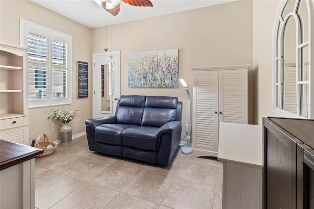 living area featuring ceiling fan and light tile patterned floors