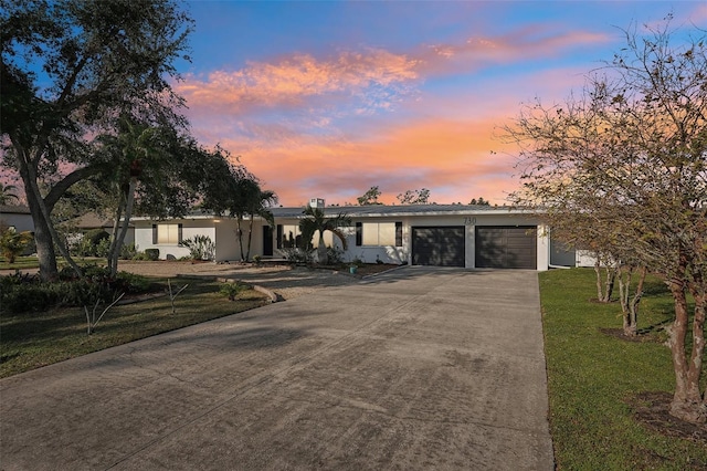 view of front of home with a garage and a lawn