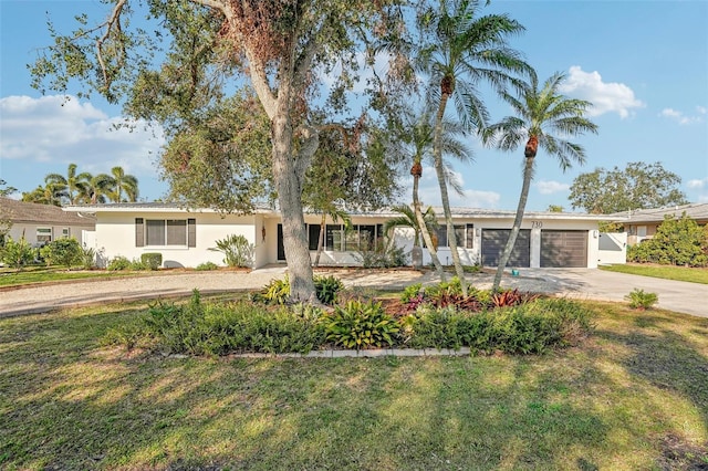 ranch-style home with a garage and a front yard