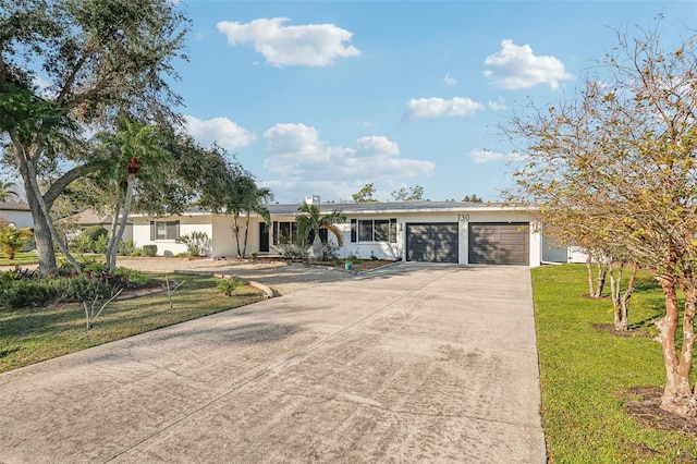 ranch-style home featuring a garage and a front yard