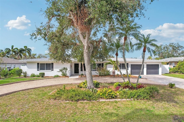 ranch-style house featuring a garage and a front lawn