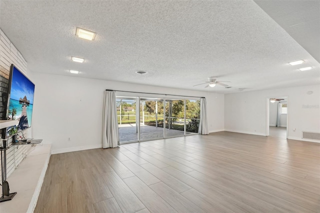 unfurnished living room with ceiling fan, light hardwood / wood-style flooring, and a textured ceiling