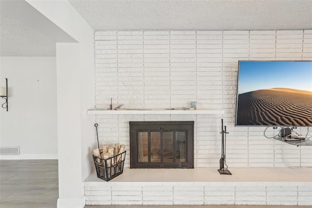 details featuring hardwood / wood-style floors, a fireplace, and a textured ceiling