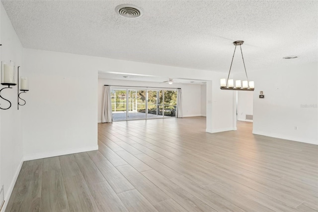 unfurnished room featuring ceiling fan, a textured ceiling, and light wood-type flooring