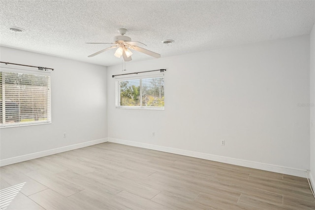 unfurnished room featuring a textured ceiling, light hardwood / wood-style flooring, and ceiling fan