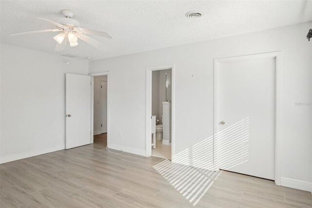 spare room featuring ceiling fan, light hardwood / wood-style floors, and a textured ceiling