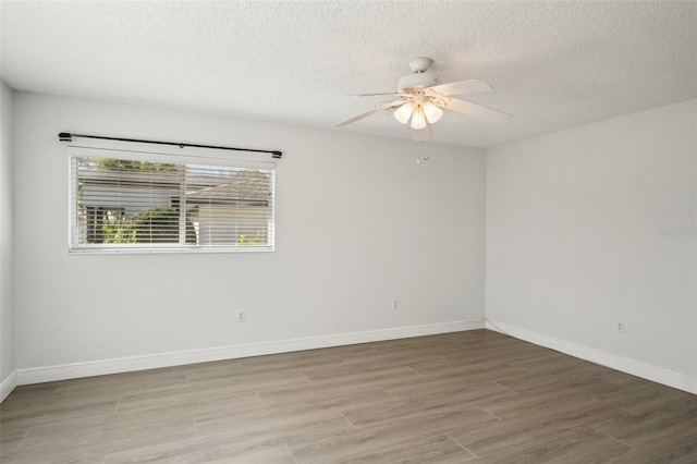 empty room featuring ceiling fan, wood-type flooring, and a textured ceiling