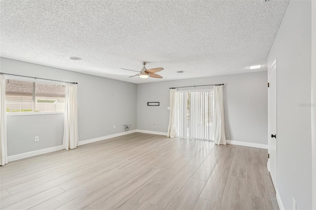 spare room featuring ceiling fan, a textured ceiling, and light wood-type flooring