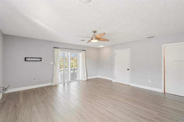 empty room featuring ceiling fan, a textured ceiling, and light wood-type flooring