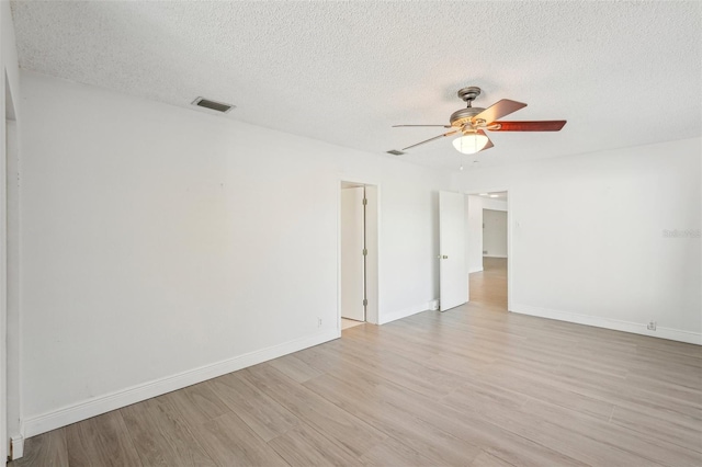 spare room with ceiling fan, light hardwood / wood-style floors, and a textured ceiling