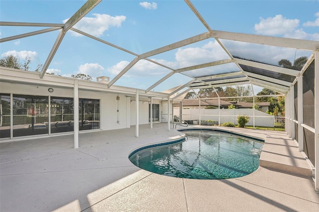 view of swimming pool featuring a patio area and glass enclosure