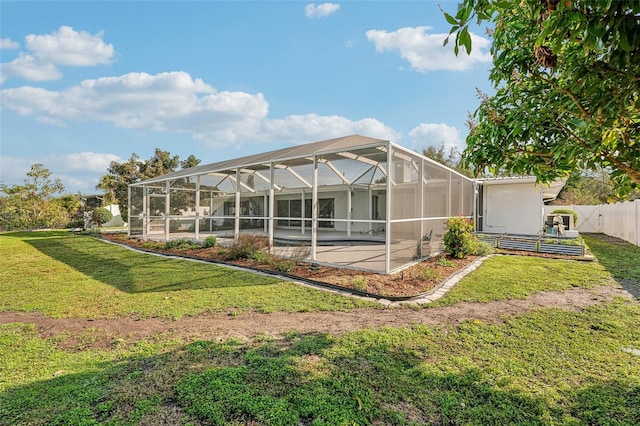 rear view of house with a lanai, a lawn, and a patio area