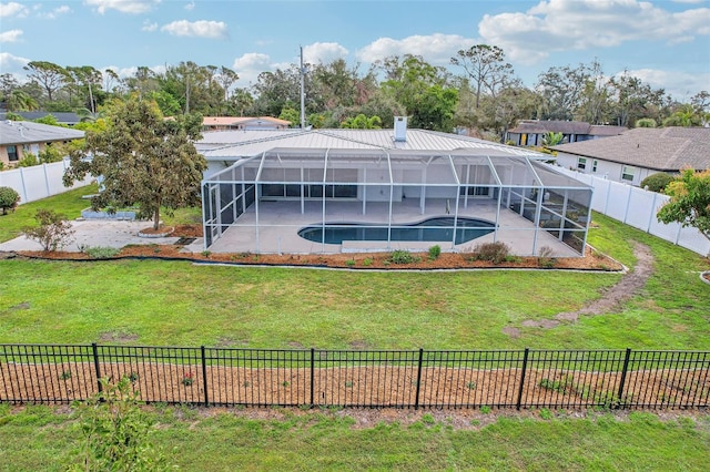 rear view of house featuring a fenced in pool, a patio area, a lawn, and glass enclosure