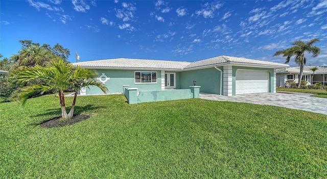 ranch-style home featuring decorative driveway, a tile roof, stucco siding, an attached garage, and a front yard