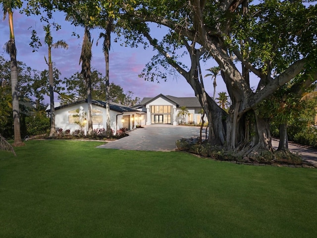 view of front of property featuring driveway and a lawn