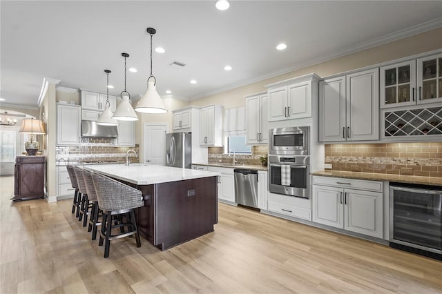 kitchen with beverage cooler, a breakfast bar, a sink, visible vents, and appliances with stainless steel finishes