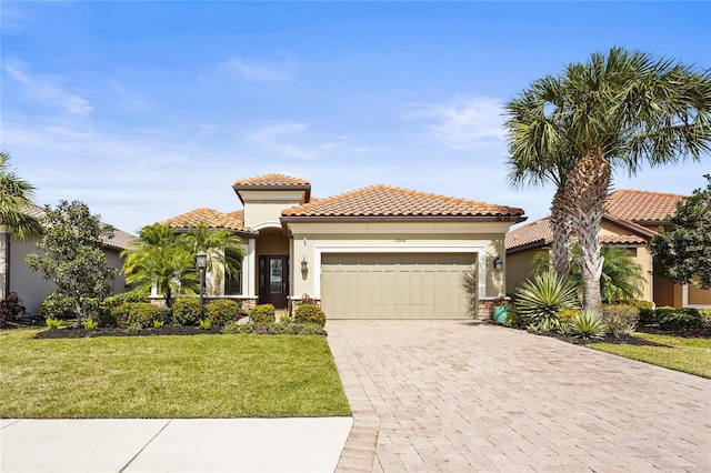 mediterranean / spanish home featuring a garage, a front yard, decorative driveway, and stucco siding