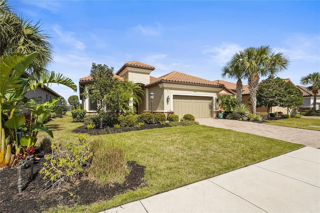 mediterranean / spanish-style home with a tile roof, an attached garage, decorative driveway, a front lawn, and stucco siding