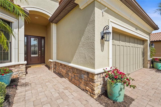 entrance to property featuring stone siding and stucco siding