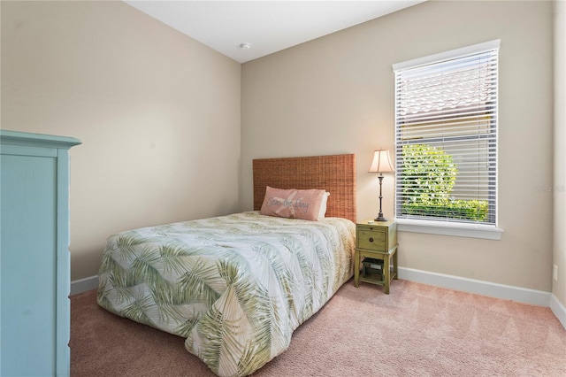 bedroom with light carpet and baseboards