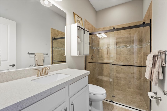 bathroom with a stall shower, vanity, toilet, and tile patterned floors