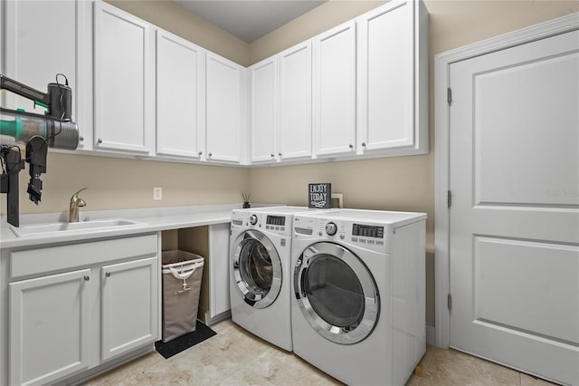 laundry room with cabinet space, a sink, and washer and clothes dryer