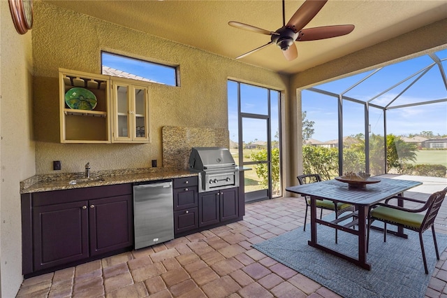 view of patio / terrace with an outdoor kitchen, a ceiling fan, glass enclosure, a grill, and a sink