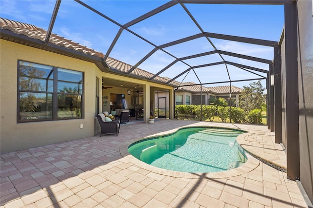 outdoor pool featuring a lanai, a patio area, and a ceiling fan