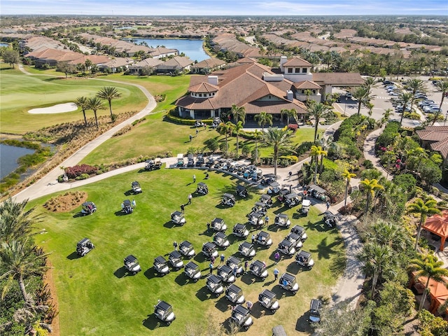 drone / aerial view with view of golf course, a water view, and a residential view