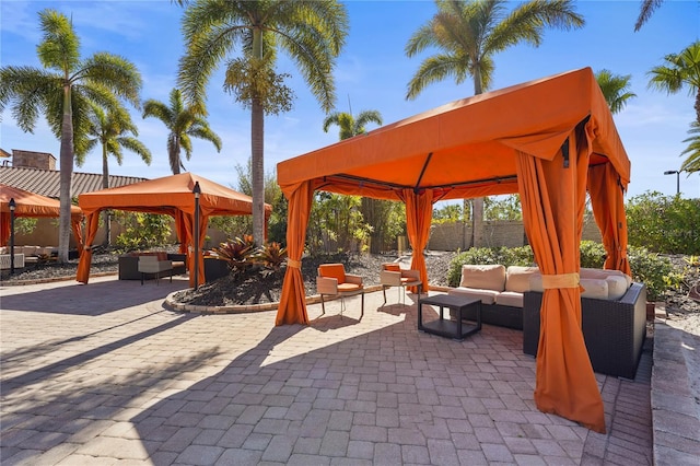 view of patio / terrace featuring outdoor lounge area, fence, and a gazebo