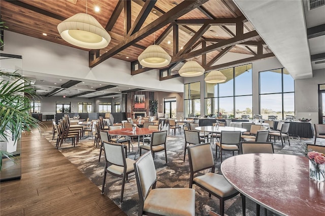 dining space featuring high vaulted ceiling, wooden ceiling, hardwood / wood-style flooring, visible vents, and beamed ceiling