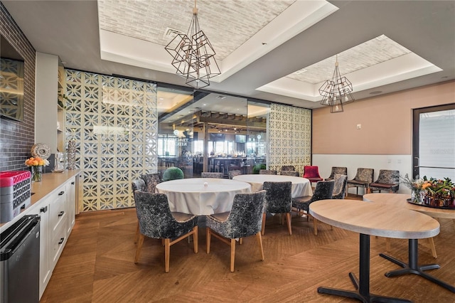 dining space with brick ceiling and a raised ceiling