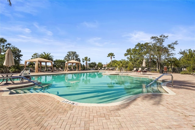 community pool with a gazebo and a patio