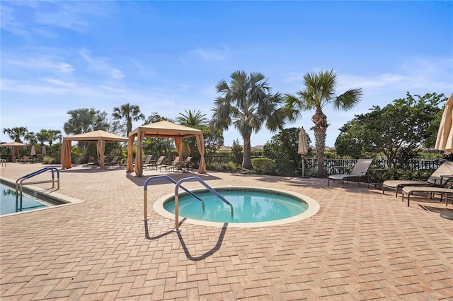 community pool featuring a gazebo, a patio area, and fence