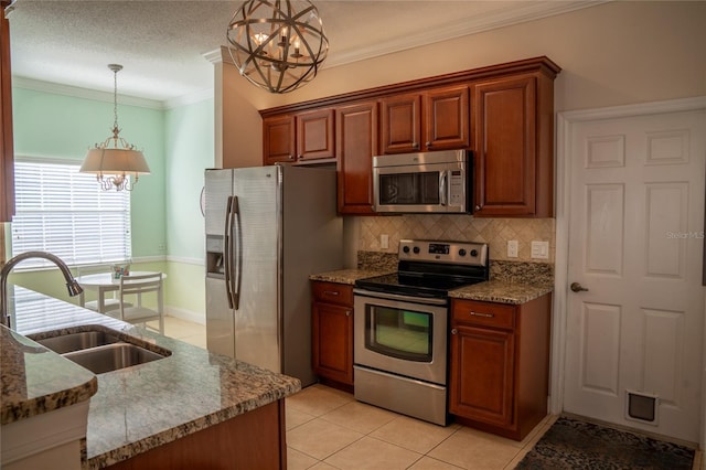 kitchen with crown molding, pendant lighting, stainless steel appliances, and a sink