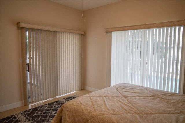 bedroom with light tile patterned flooring and baseboards