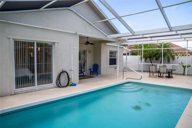 view of swimming pool with a fenced in pool, a patio, a ceiling fan, glass enclosure, and a fenced backyard